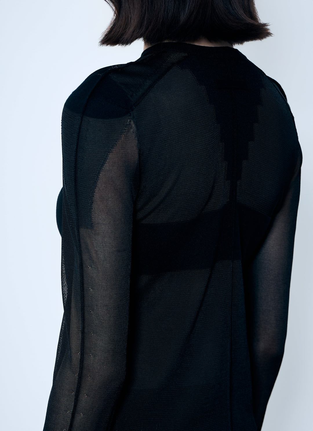 Black sheer long-sleeve top on a plain background