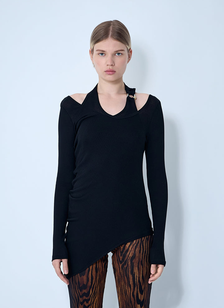 Model wearing a black long-sleeve top with a unique design on a light blue background