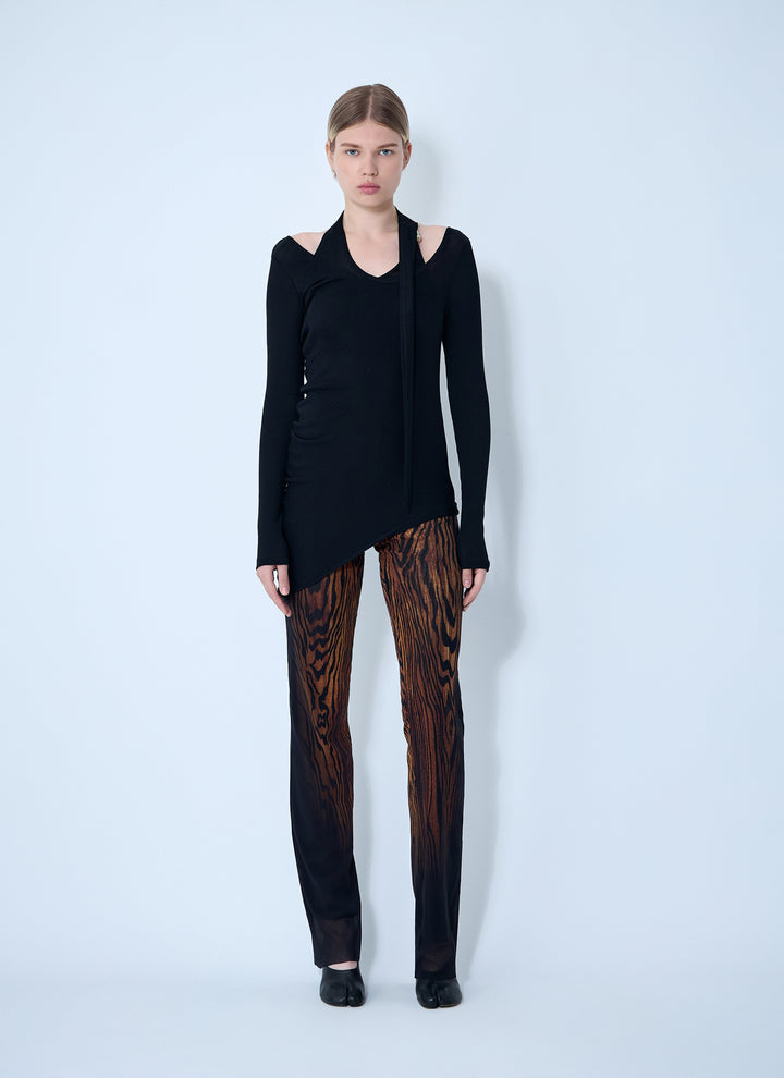 Woman wearing a black outfit with a unique pattern on a light blue background