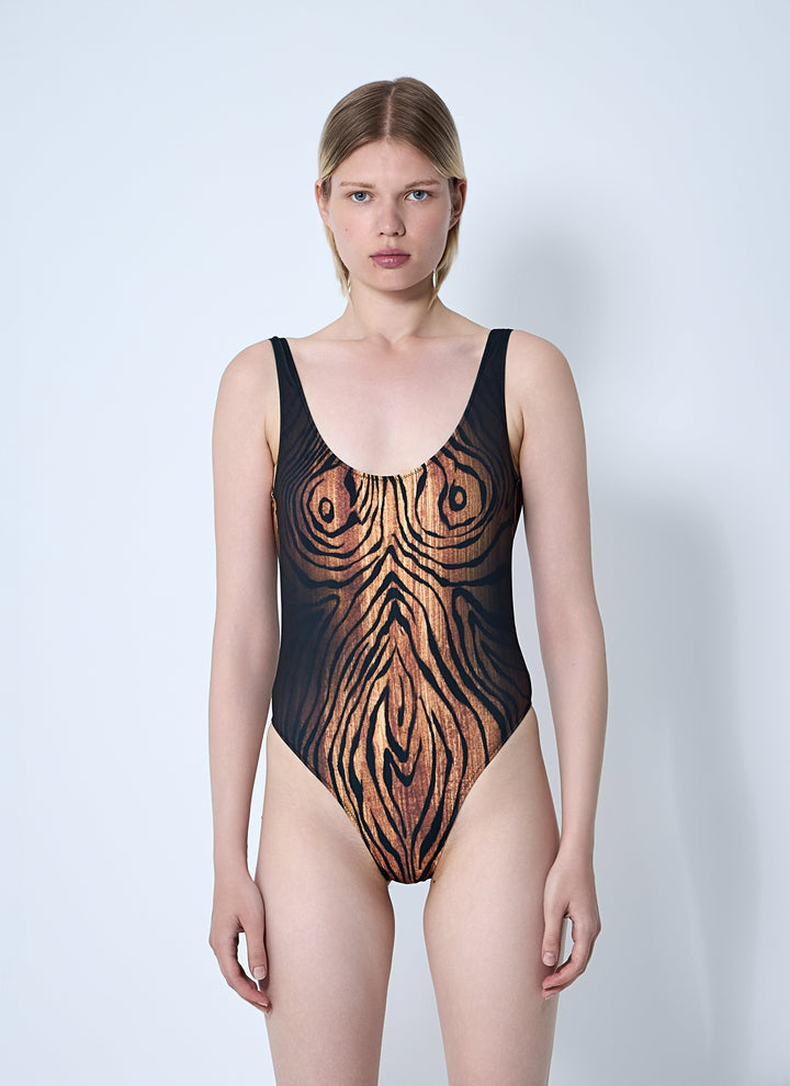 Woman wearing a black and brown zebra print swimsuit on a white background