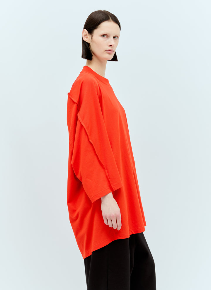 Person wearing a bright orange top on a light gray background