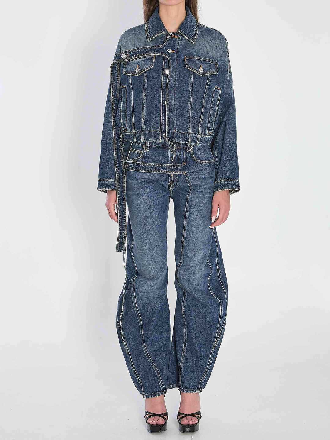Person wearing a denim jacket and jeans on a white background