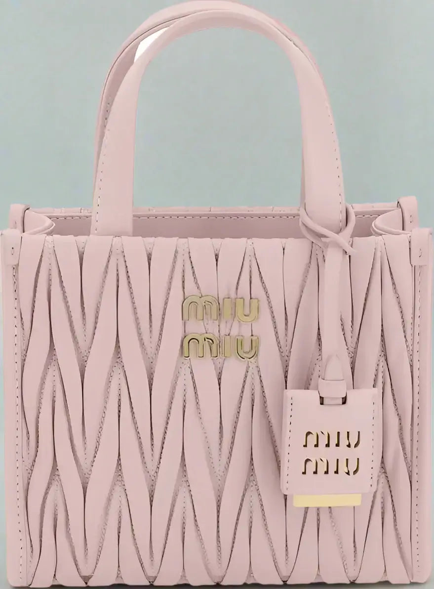 Pink handbag with quilted design and Miu Miu logo on a white background