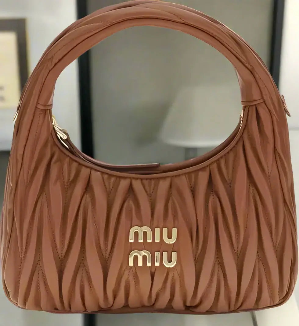 Brown handbag with 'miu miu' logo on a white background