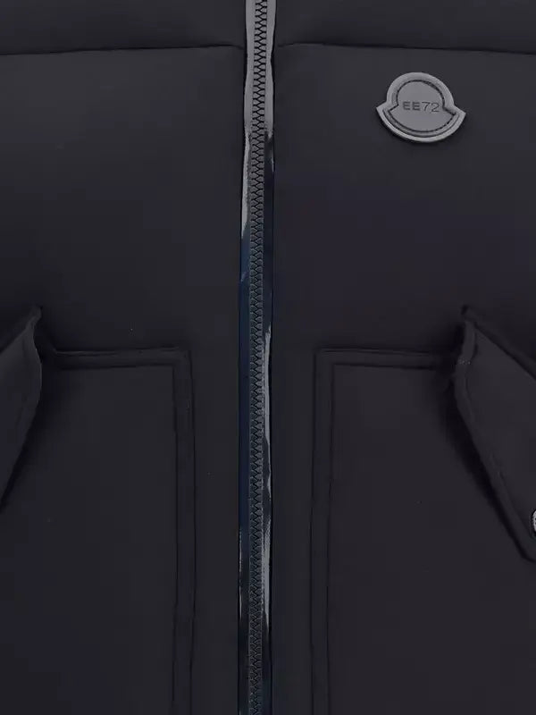 Close-up of a black jacket with a zipper and brand logo on a dark background