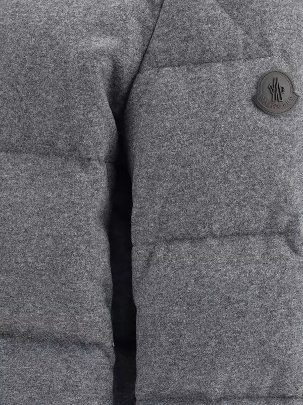 Close-up of a gray textured fabric with a button featuring a logo.