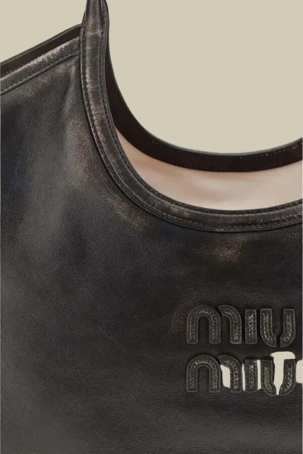 Black handbag with 'miu miu' logo on a white background