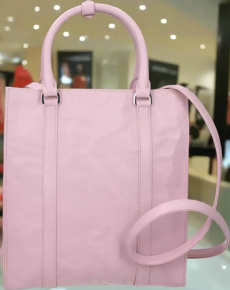Pink tote bag with a shoulder strap on a white background