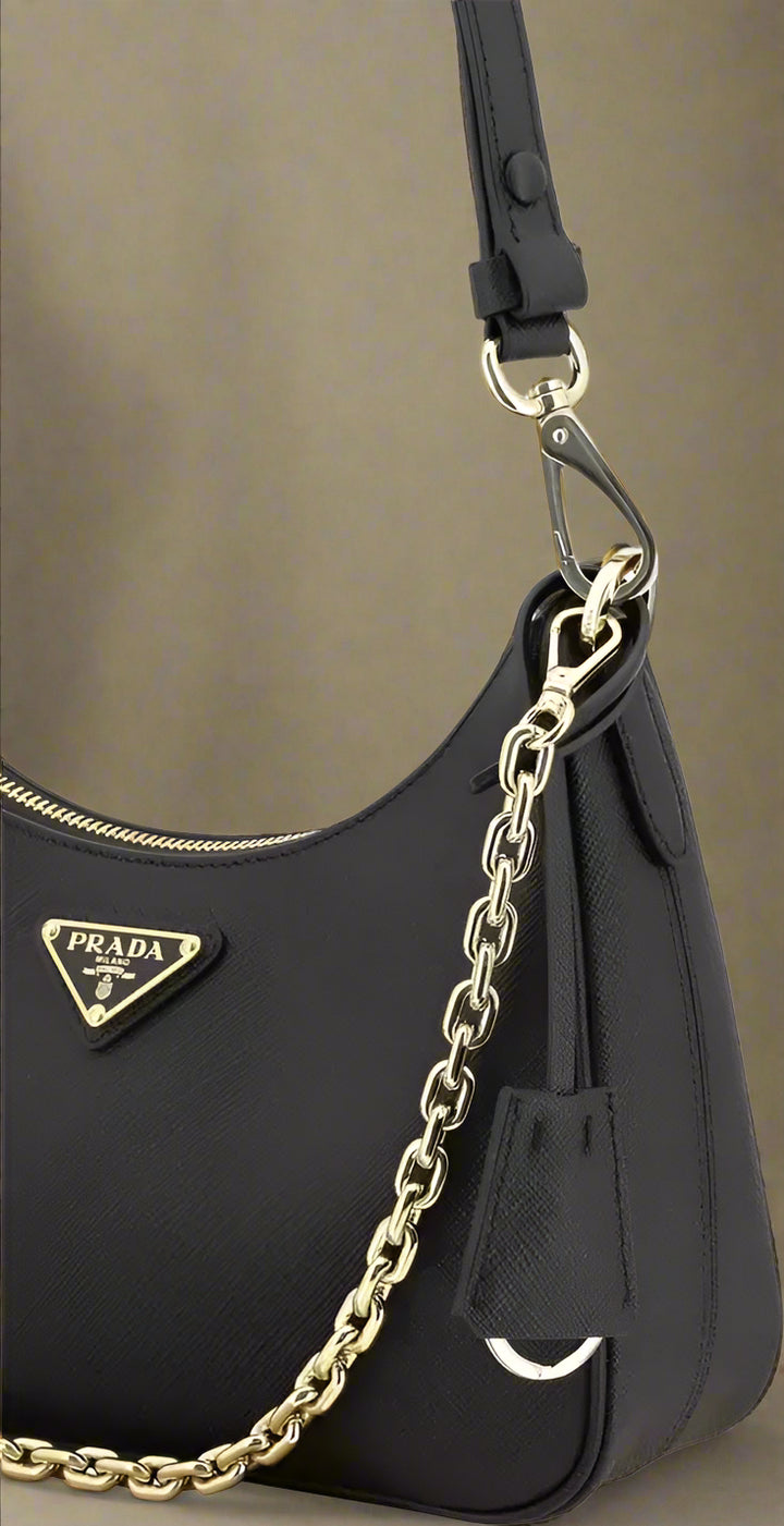 Black Prada handbag with gold chain strap on a white background