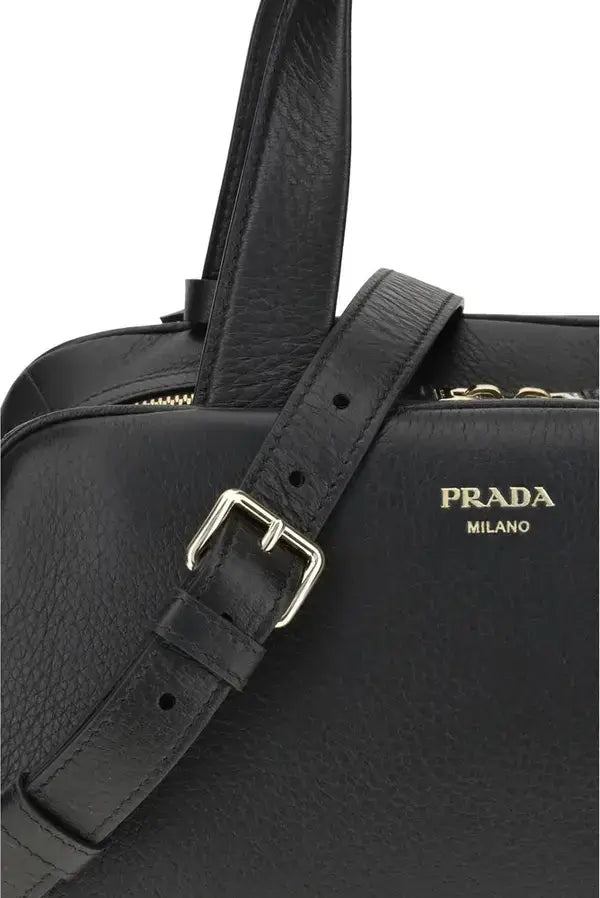 Black Prada handbag with gold buckle on a white background