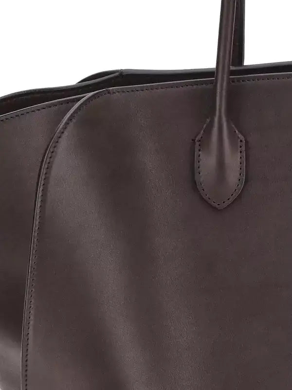 Close-up of a dark brown leather handbag with a visible brand logo.