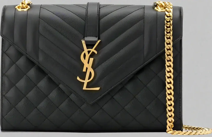 Black quilted handbag with gold chain and logo on a white background
