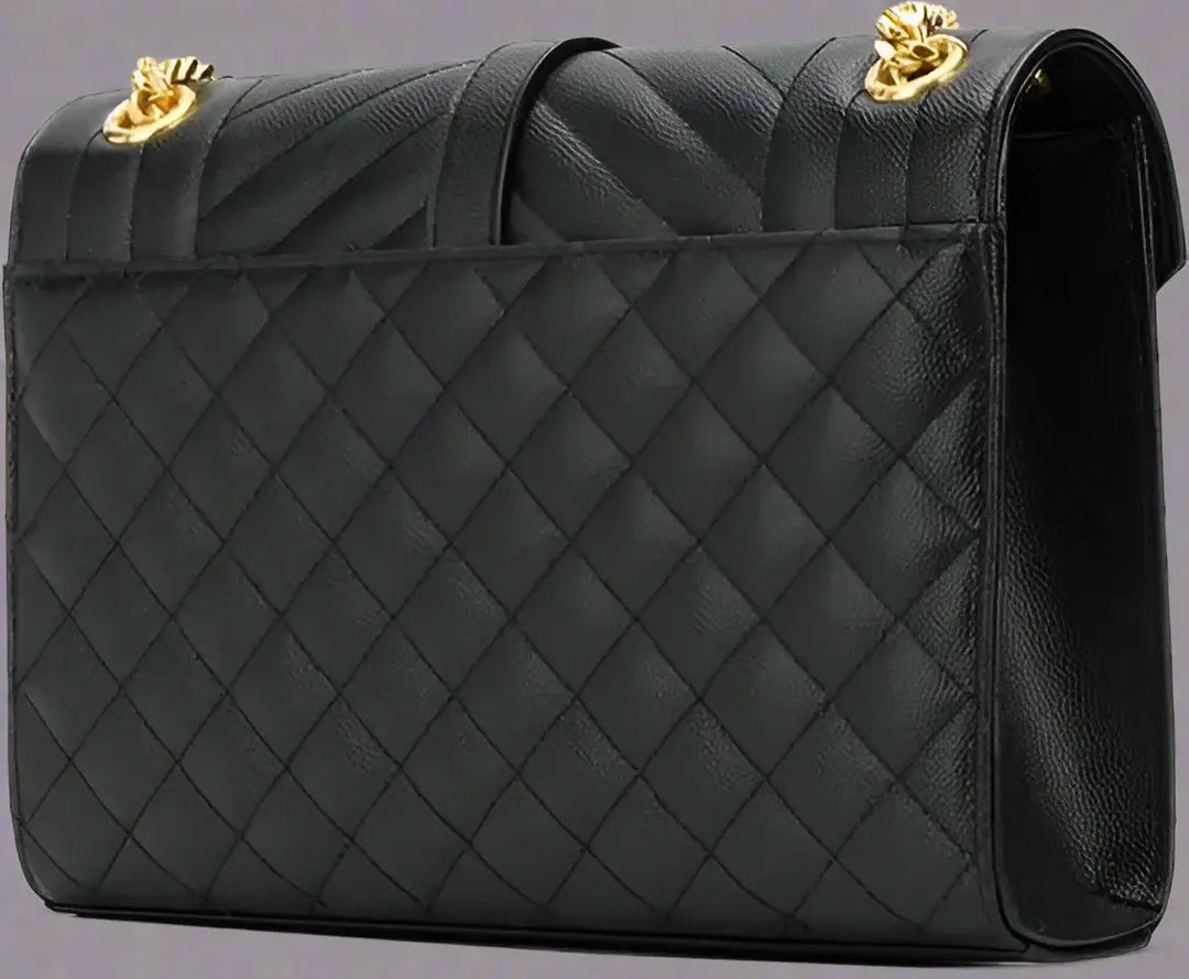 Black quilted handbag with gold hardware on a white background