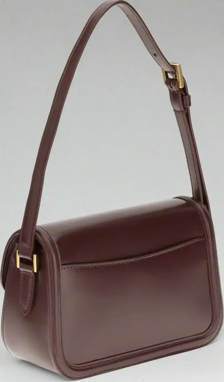 Brown leather handbag with a strap on a white background