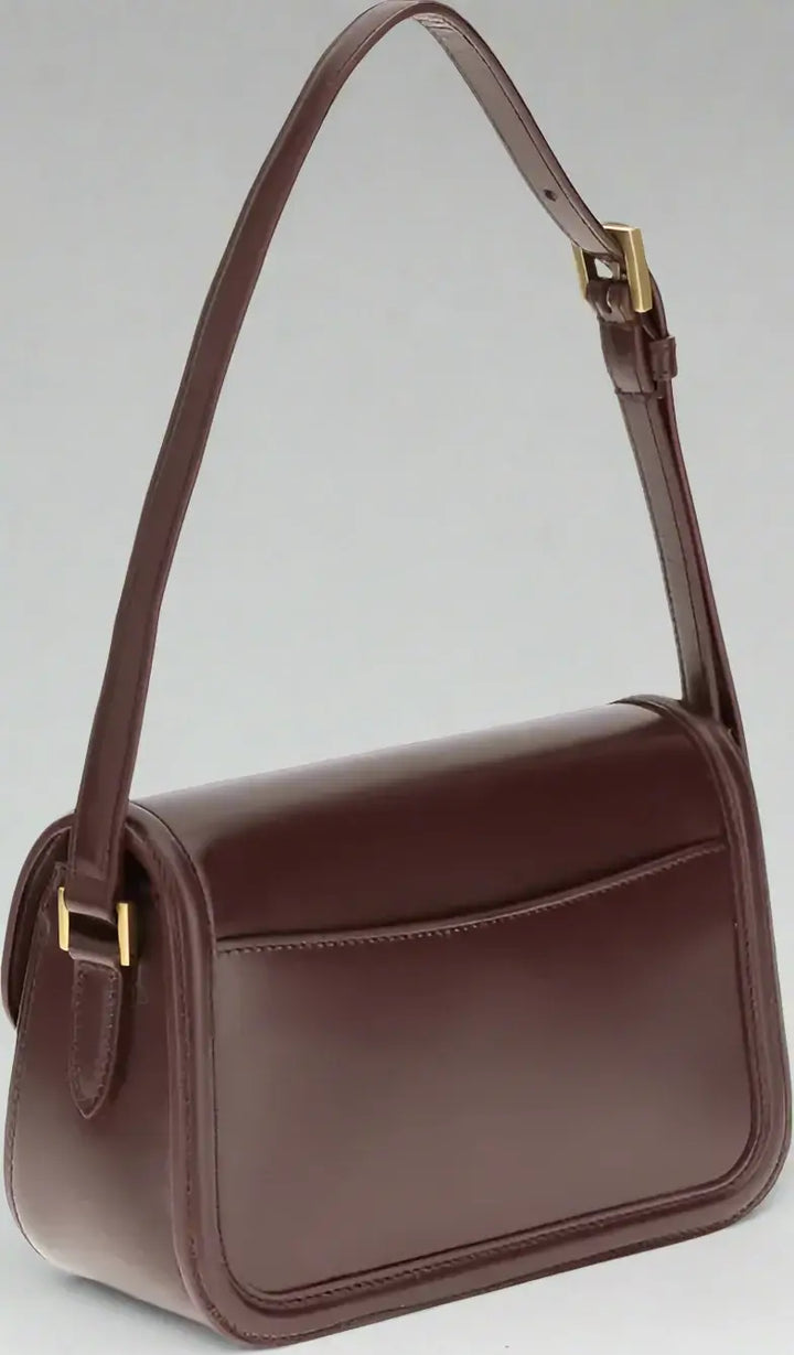 Brown leather handbag with a strap on a white background