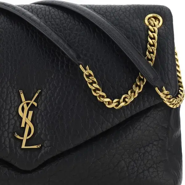 Black handbag with gold chain handle and YSL logo on a white background