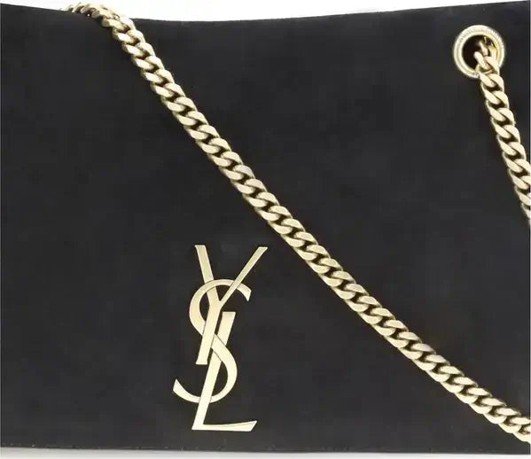 Black handbag with gold chain strap and YSL logo on a black background