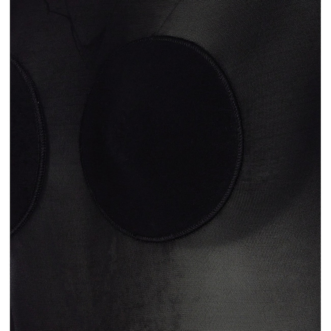Close-up of a black circular object on a textured black surface