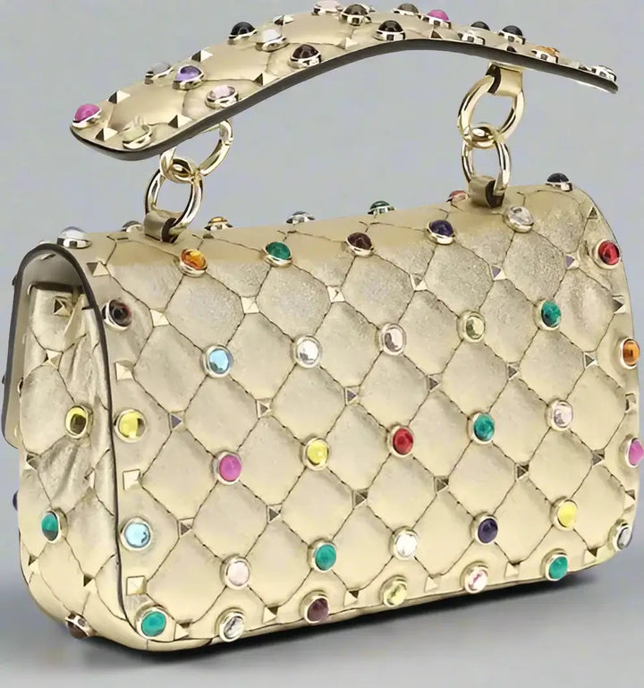 Gold handbag with colorful gemstones on a white background