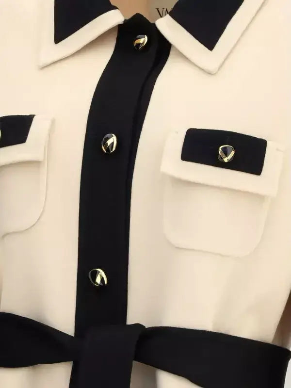 Close-up of a black and white coat with gold buttons