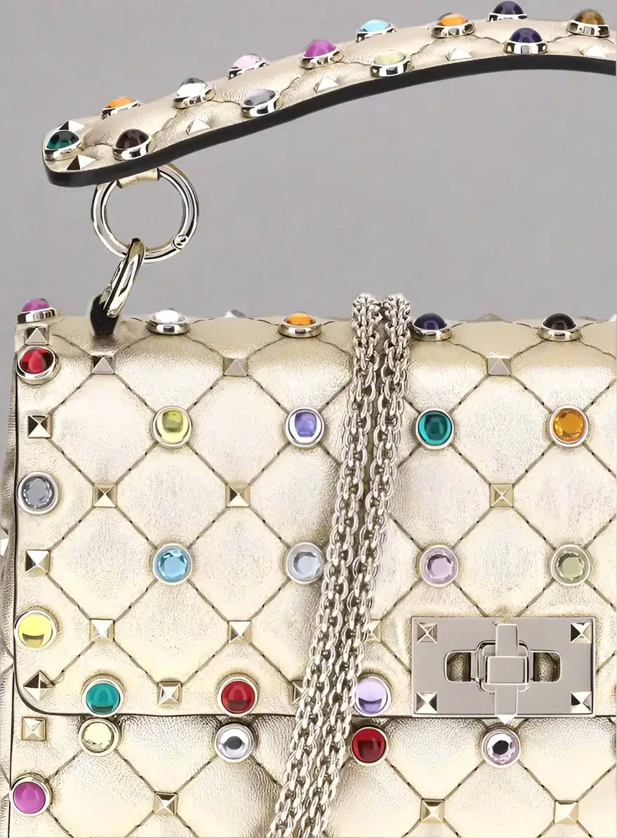 Luxury handbag with colorful gemstones and a chain detail on a white background