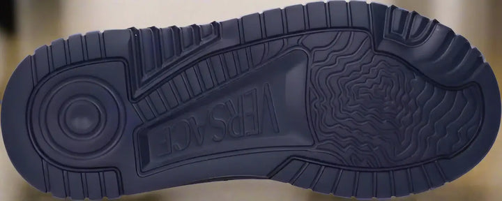 Navy blue sneaker sole with 'Versace' branding on a white background