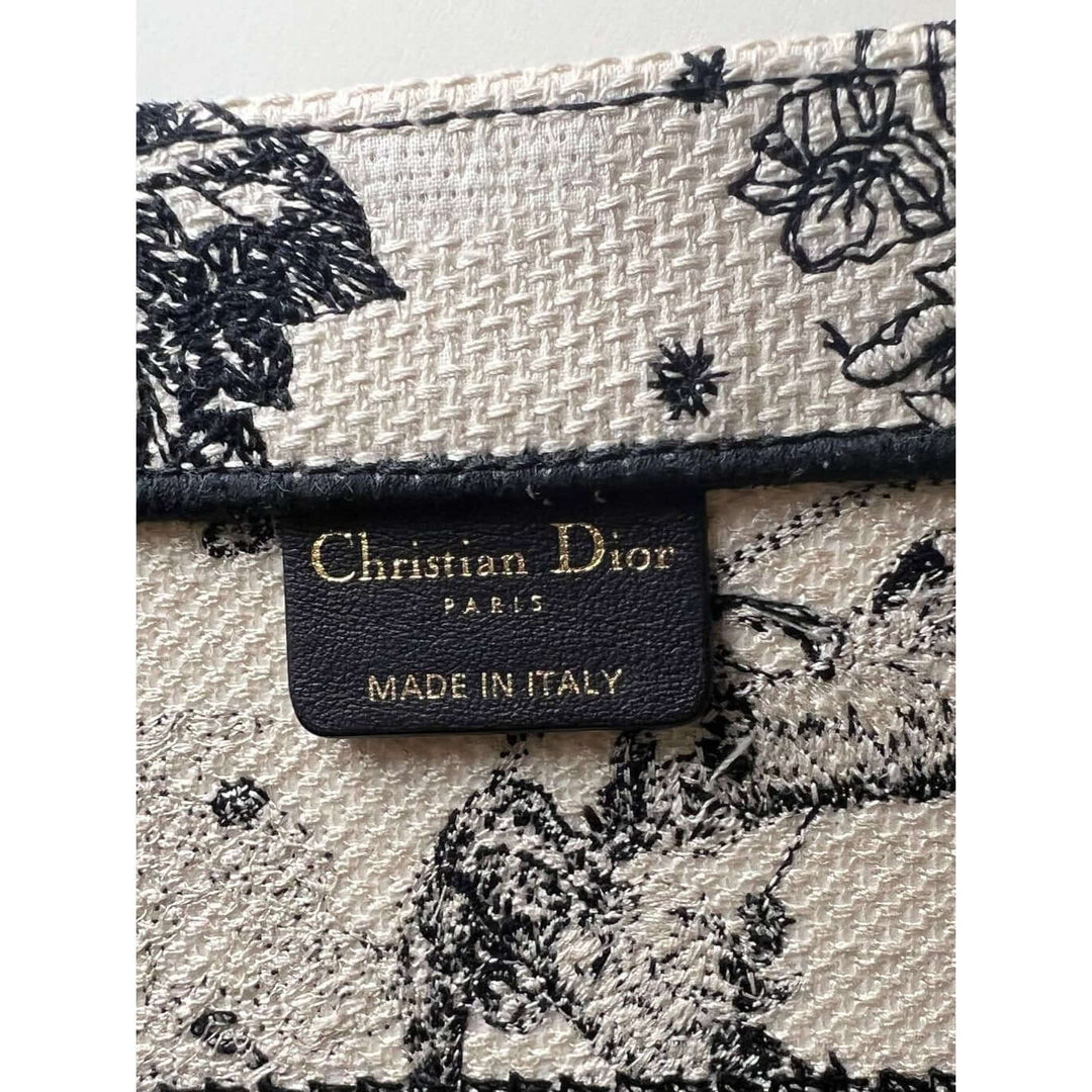 Christian Dior Book Embroidered Canvas Medium Stars and Signs Black Tote label showcasing luxury craftsmanship and authentic branding.