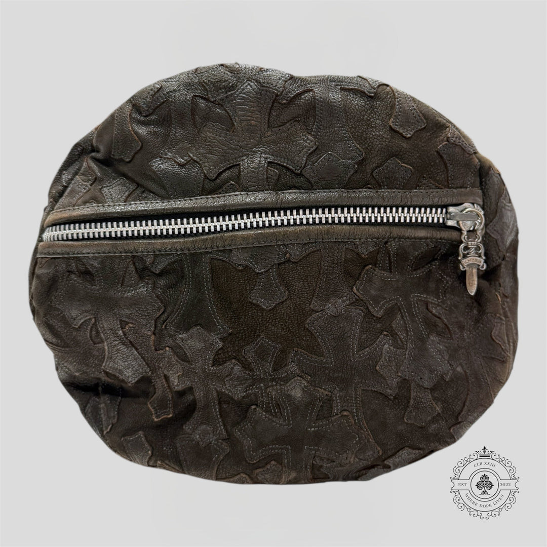 Dark brown leather bag with floral patterns and a silver zipper on a light gray background.