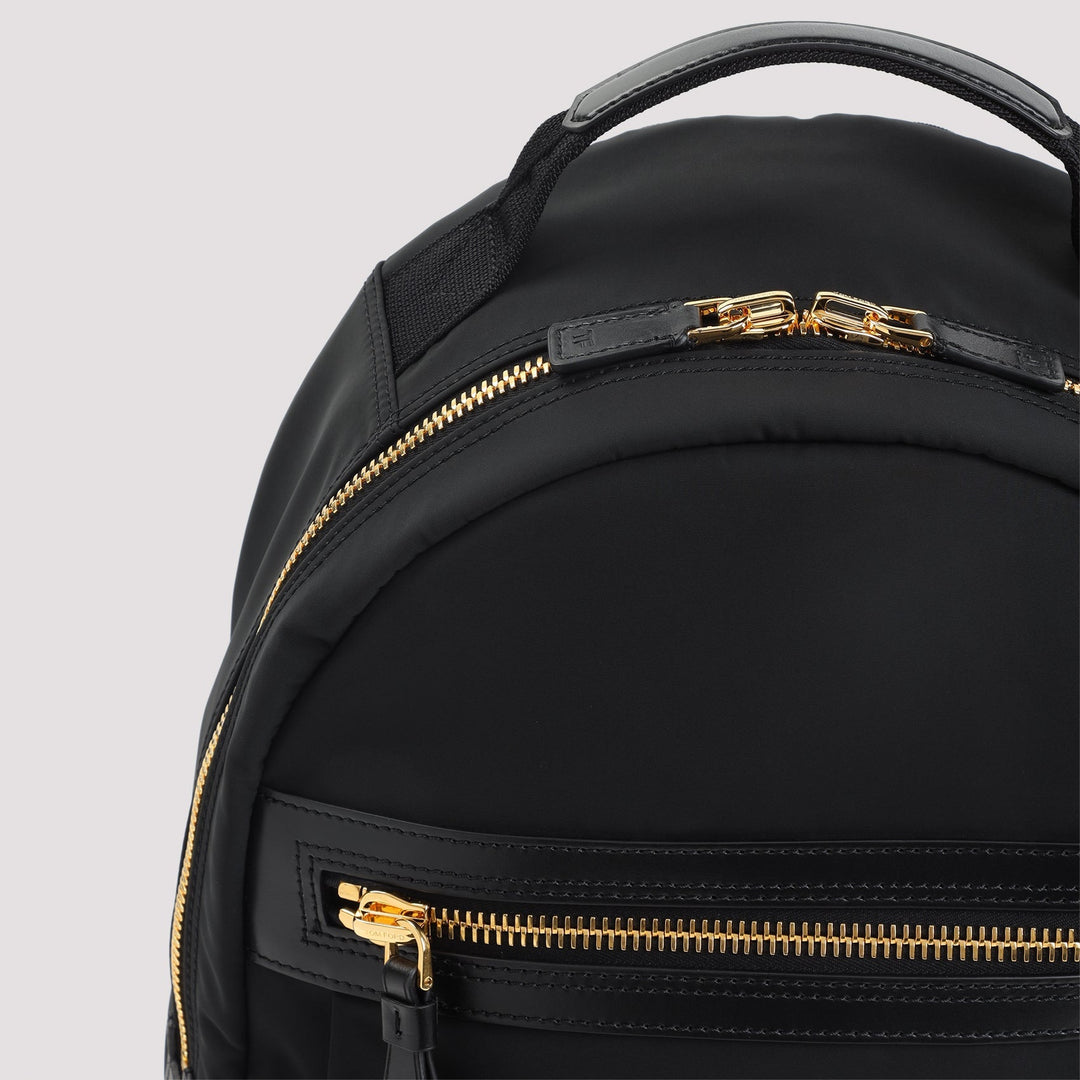 Black backpack with gold zippers on a light gray background