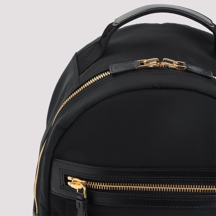 Black backpack with gold zippers on a light gray background