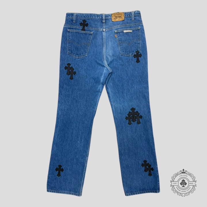 Chrome Hearts Cross Patch Levis in dark indigo, featuring rare .925 sterling silver hardware and unique cross patches.