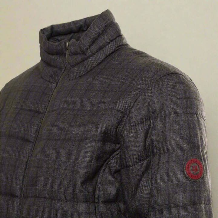 Gray quilted jacket with a red logo patch on a white background