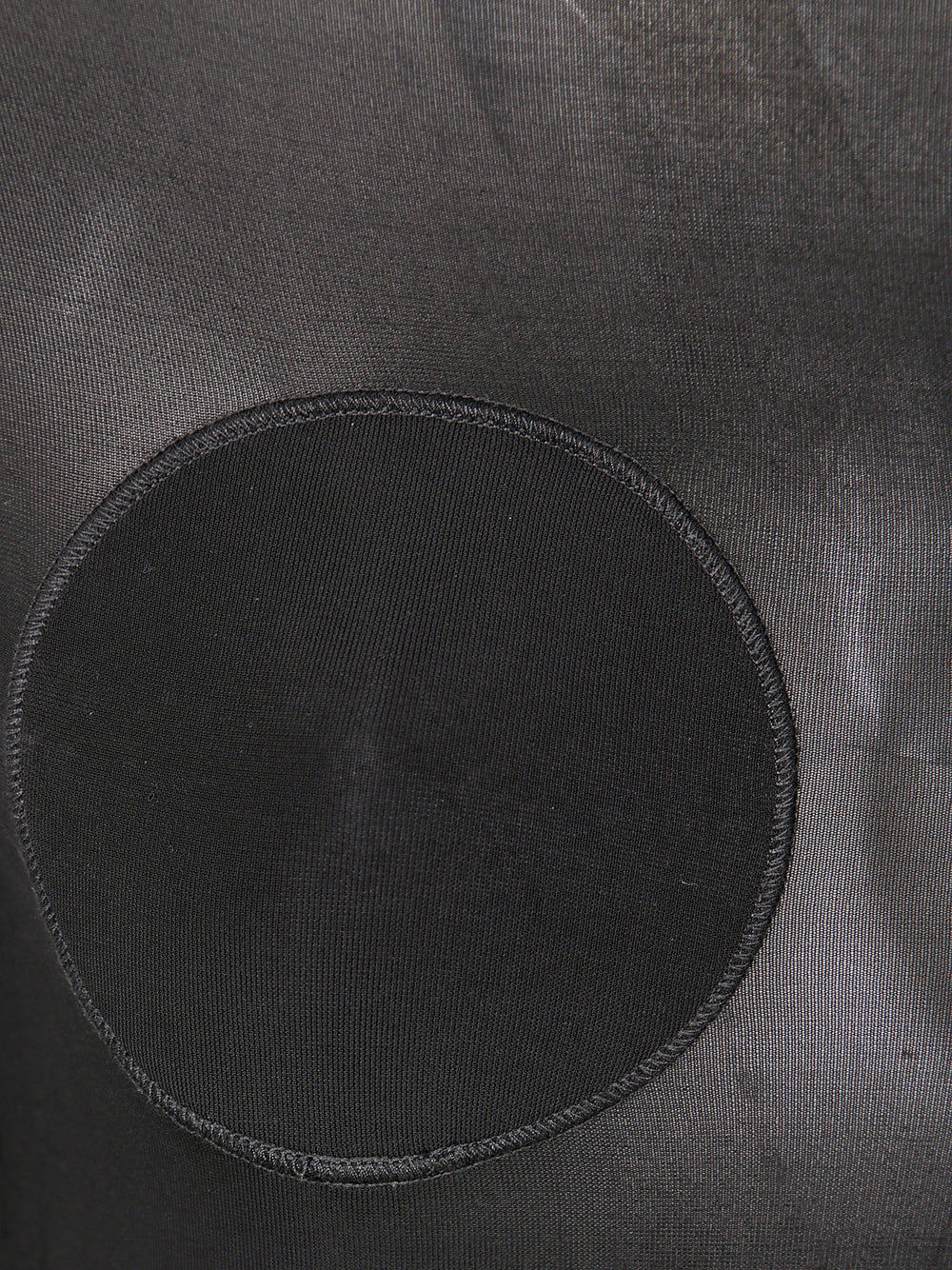 Black circular patch on a textured gray surface