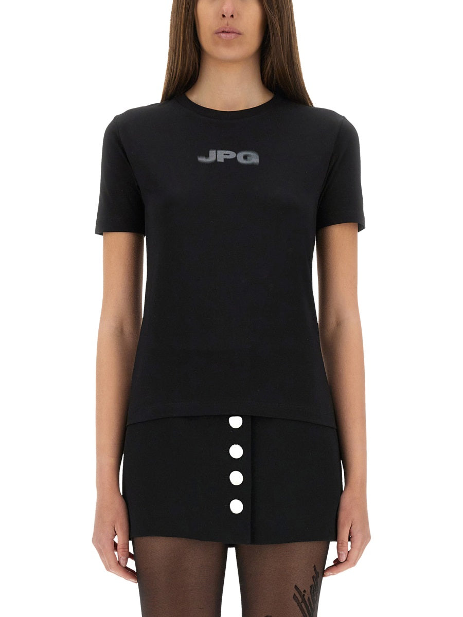 Person wearing a black t-shirt with 'JPG' logo and a black skirt with white buttons on a white background
