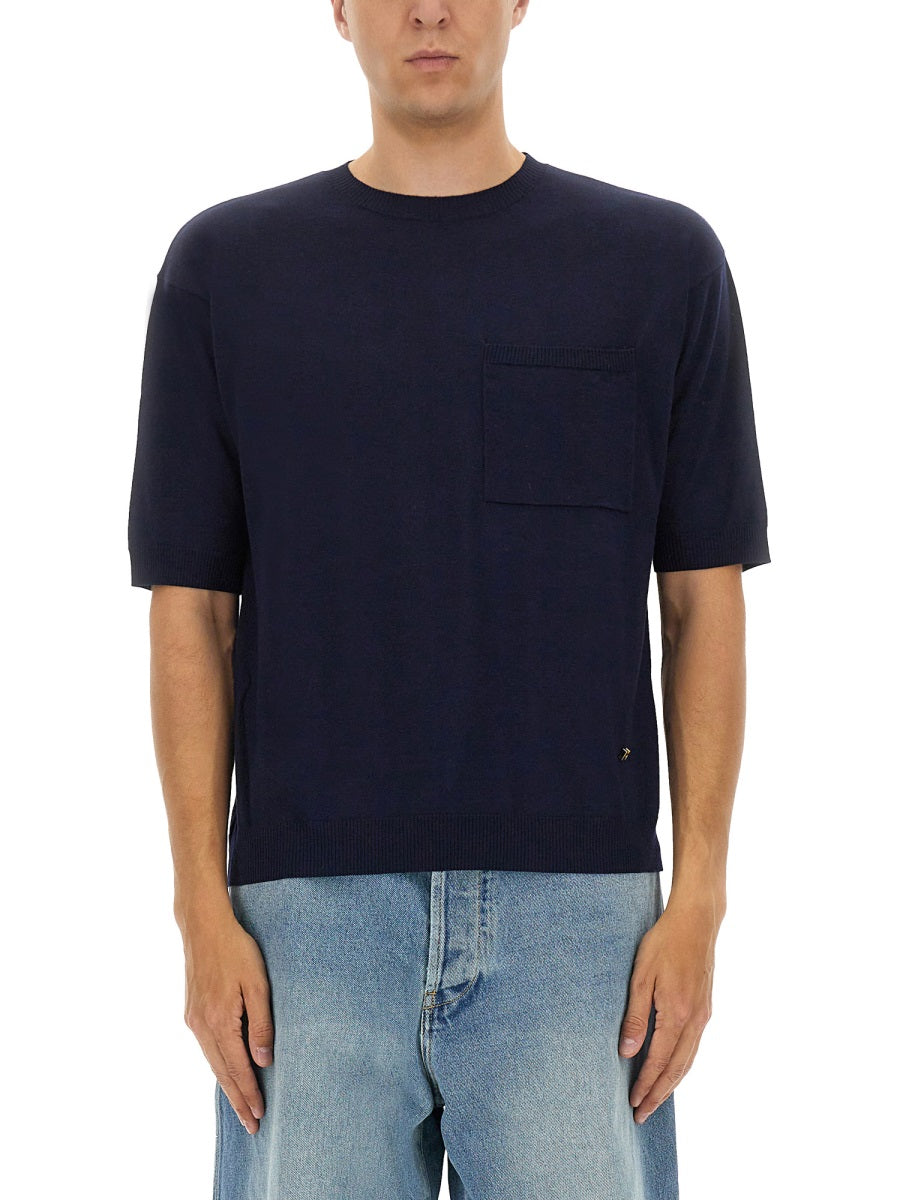 Man wearing a navy blue t-shirt with a pocket on a white background