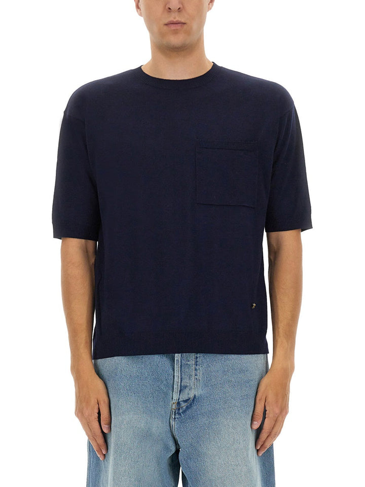 Man wearing a navy blue t-shirt with a pocket on a white background