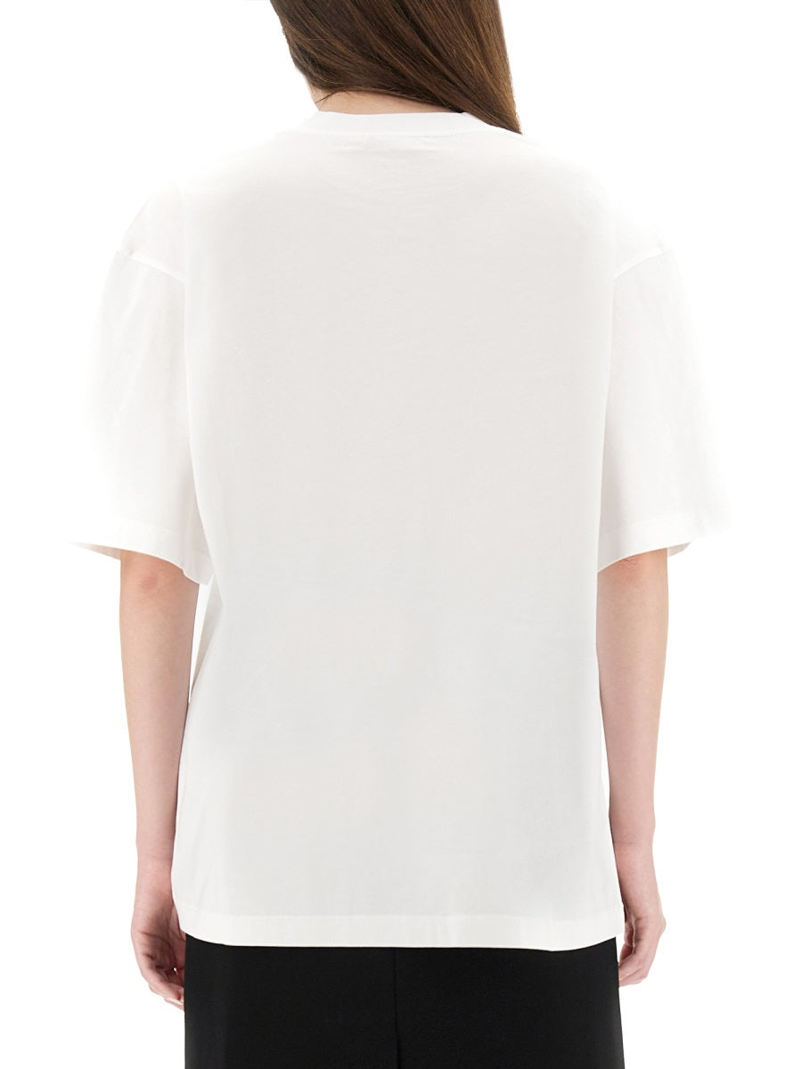 Person wearing a white t-shirt on a plain background