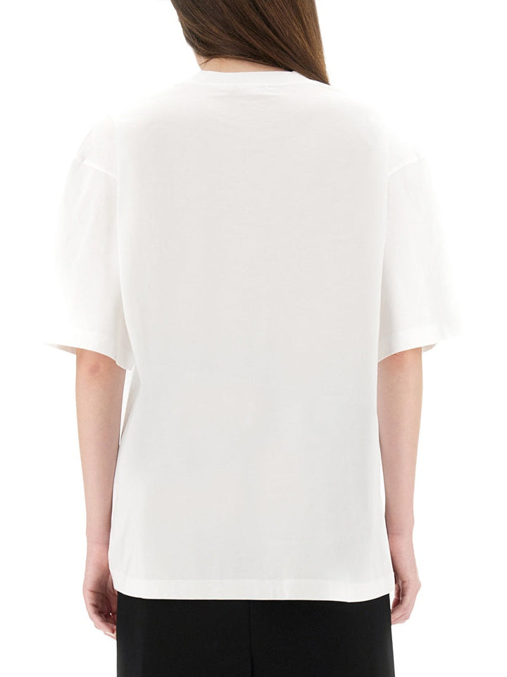 Person wearing a white t-shirt on a plain background