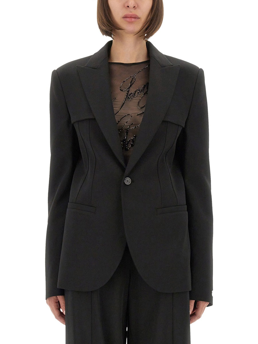 Black suit jacket worn by a person on a white background