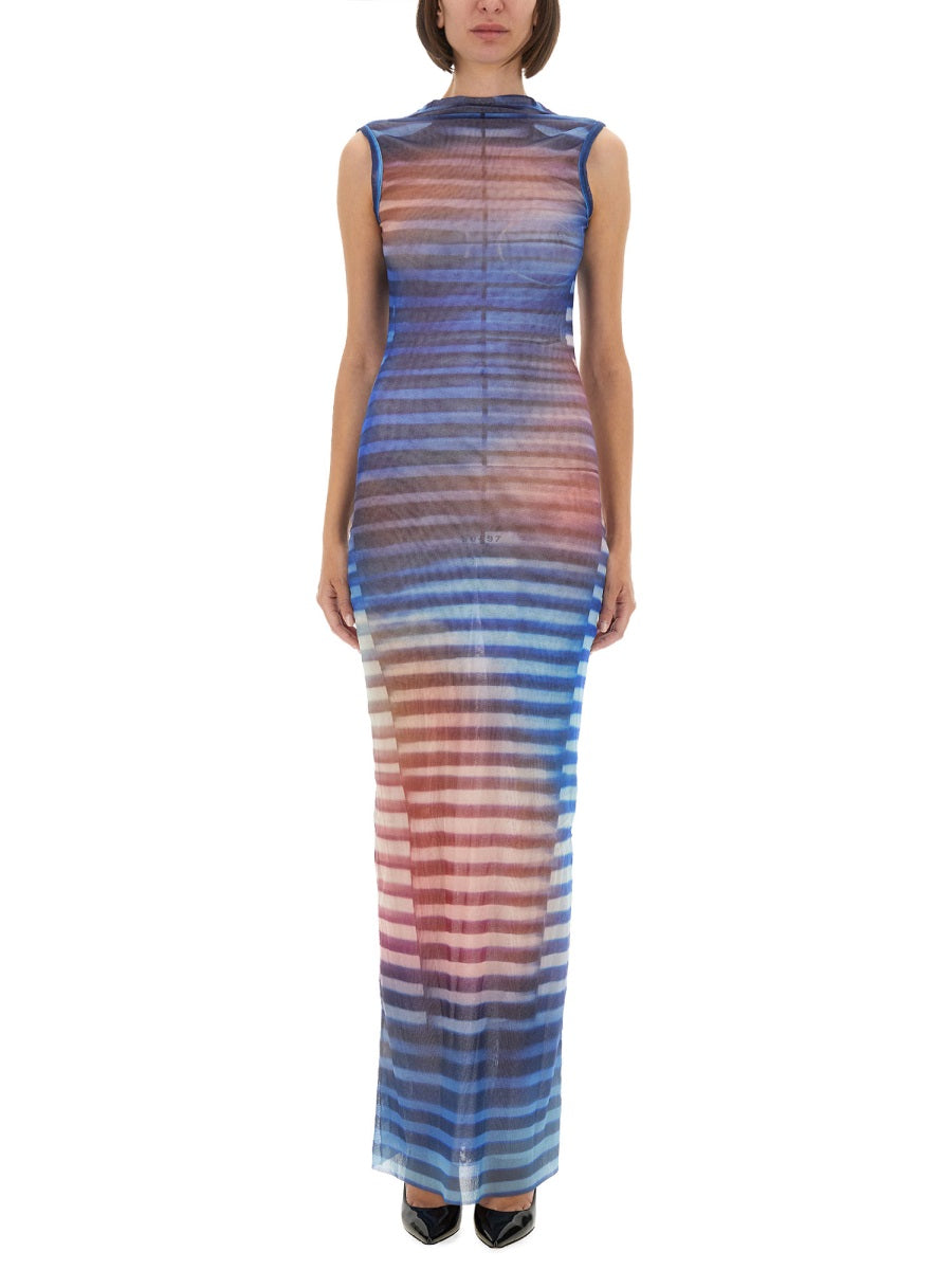 Woman wearing a sleeveless, long, multicolored dress with a gradient effect on a white background.