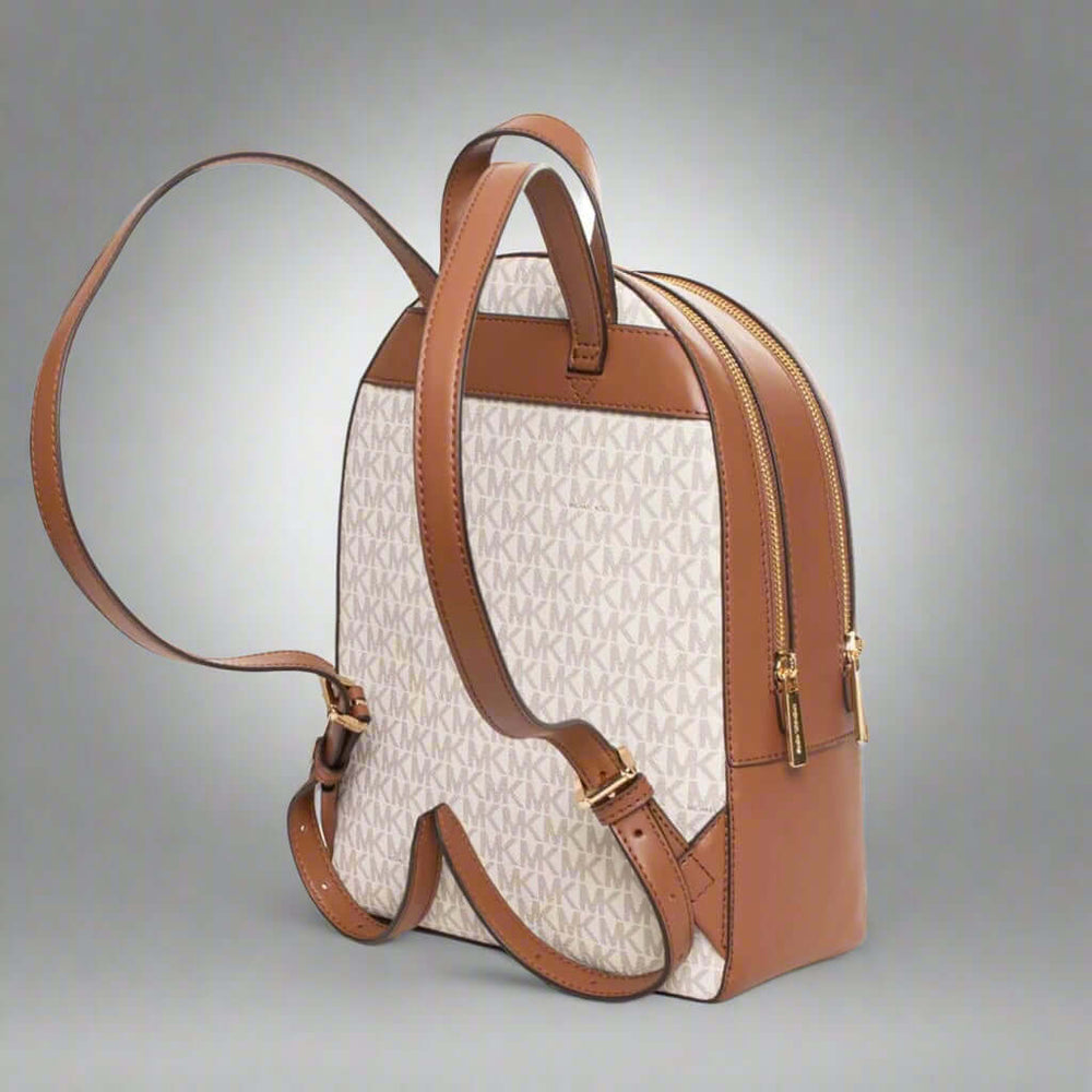Backpack with brown leather straps and trim on a white background
