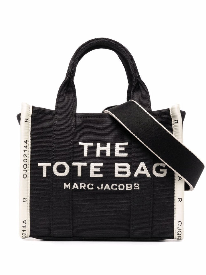 Black tote bag with 'The Tote Bag' and 'Marc Jacobs' text on a white background