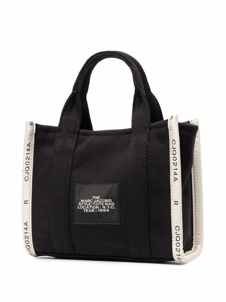 Black tote bag with white accents and branding on a white background