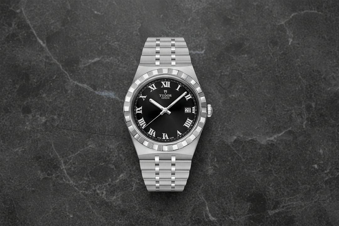 Silver Tudor watch with black dial on a white background