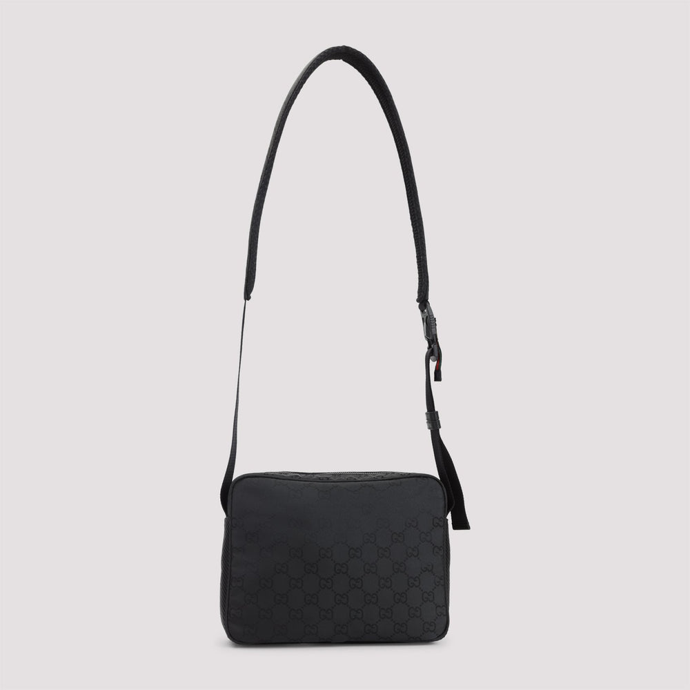 Black quilted handbag with a strap on a light gray background