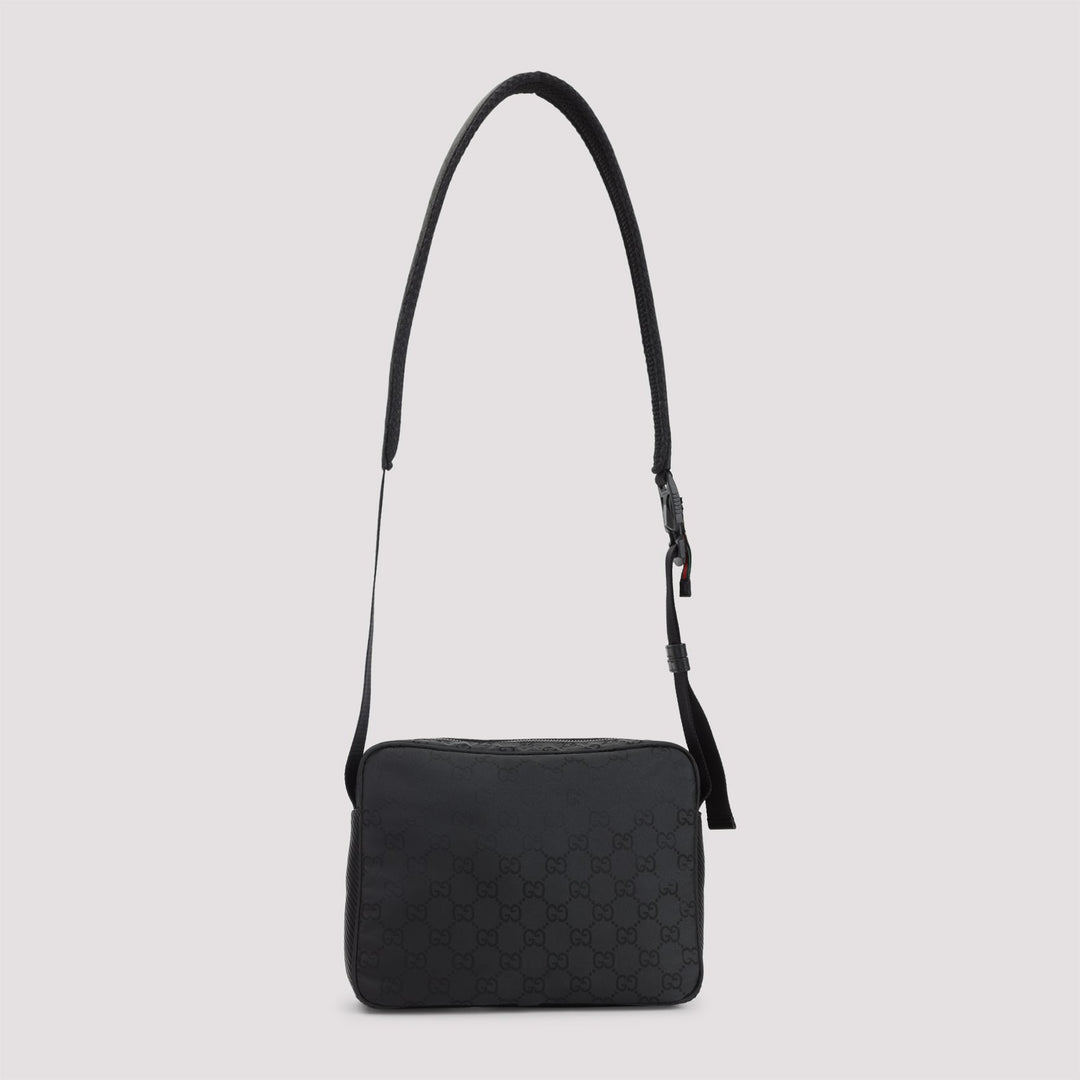 Black quilted handbag with a strap on a light gray background