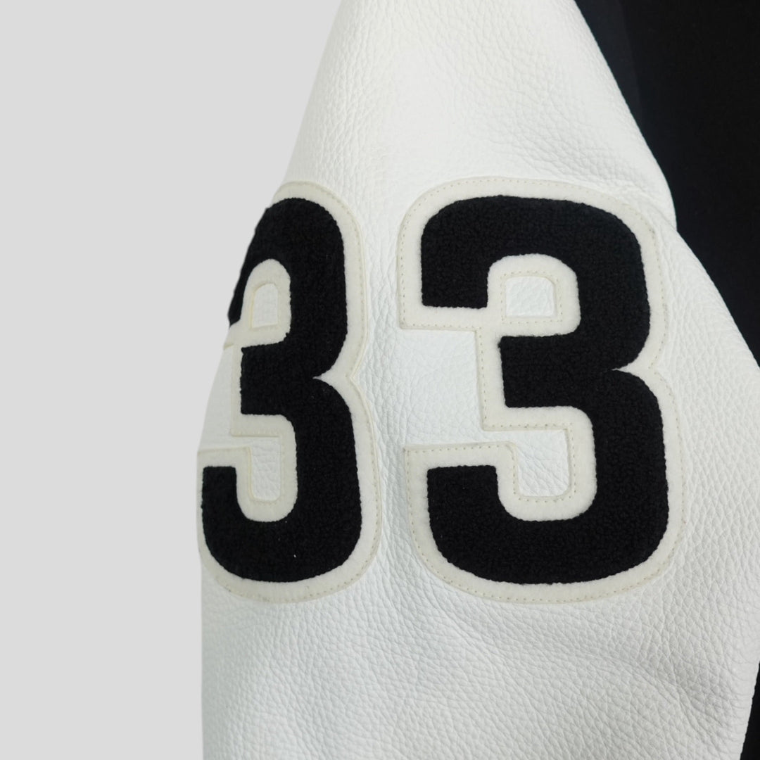 Close-up of a white basketball with black number 33 on a light gray background