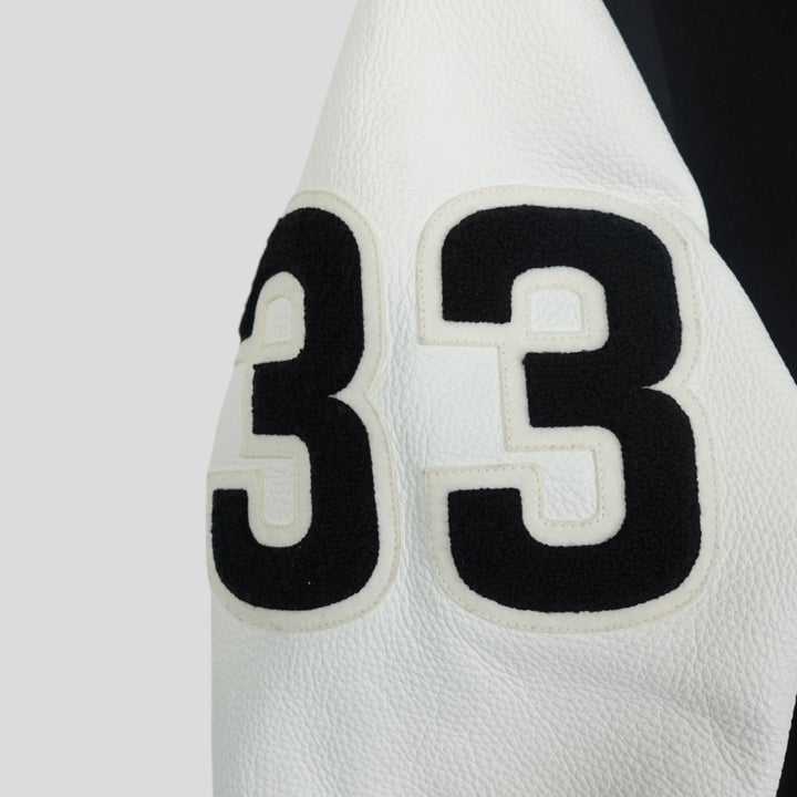Close-up of a white basketball with black number 33 on a light gray background