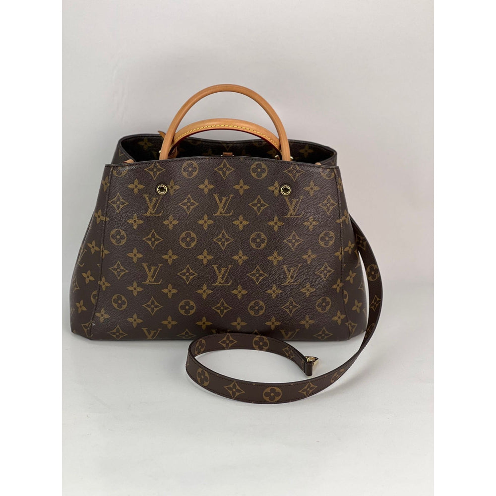 Brown handbag with monogram pattern on a white background