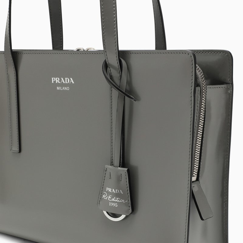 Gray Prada handbag with a strap and tag on a white background